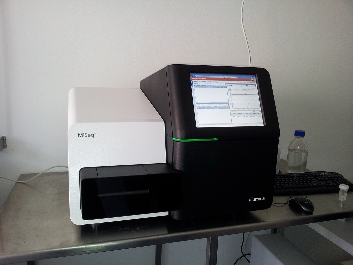 A sequencing instrument reading millions of short fragments at once; software reassembles them into a genome.
